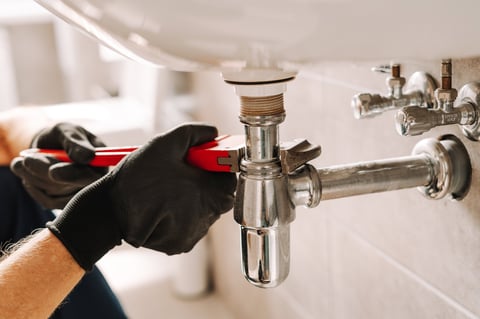 Plumber fixing sink pipe