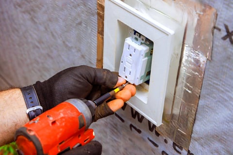 Electrician installing electrical outlet